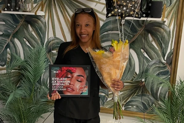 Connecticut lash license program graduate proudly holding license paperwork